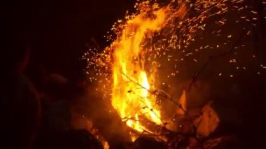 Dağlarda yürüdükten sonra gece kıvılcımlarla yanan şenlik ateşine yakın bir yerde.