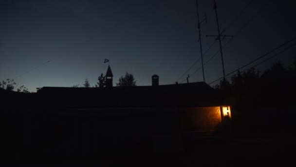 Silueta de la casa en la noche con una linterna ardiente en el porche — Vídeo de stock