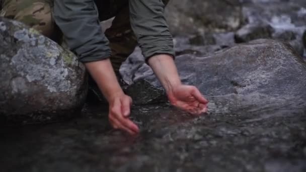 Πεζοπόρος πίνει νερό από ένα ρυάκι του βουνού. — Αρχείο Βίντεο