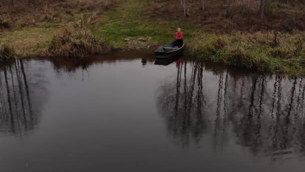 Girando intorno di ragazza dai capelli biondi seduta in una barca sul fiume — Video Stock