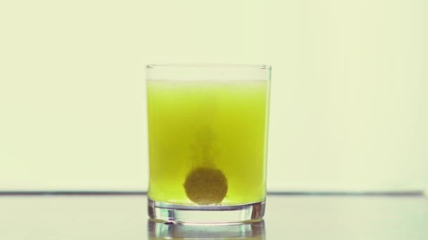 Lemon flavored vitamin C effervescent tablet dissolvs in a glass of fresh water — Vídeo de Stock