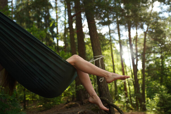 A lonely pretty bare woman legs moving up and down in gentle sun