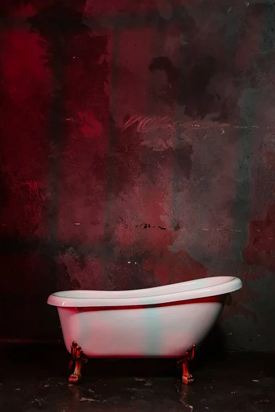 Біла ванна на червоній кривавій стіні Стокове Фото