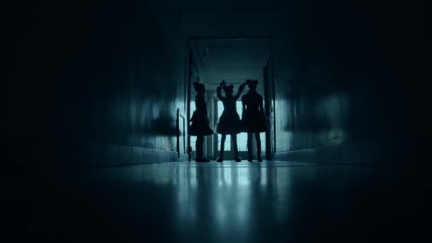 Um corredor assustador com três meninas. Silhuetas assustadoras estão se aproximando. — Vídeo de Stock