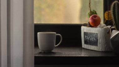 Sabah taze demlenmiş kahve, beyaz bir espresso bardağında, ahşap bir pencere eşiğinde.
