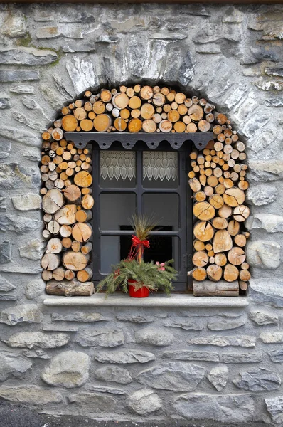 Ventana en la casa de piedra con pila de madera —  Fotos de Stock