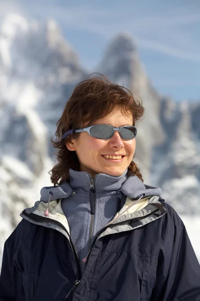 The girl in glasses on a background of snow mountains — Stock Photo, Image