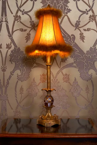 Antica lampada in una camera da letto su un comodino — Foto Stock