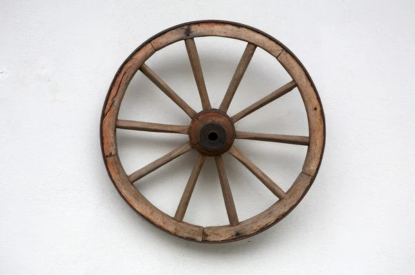 Old wheel of a cart on a white wall — Stock Photo, Image