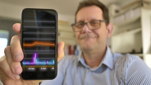 Człowiek Posiadający Smartfon Informacjami Akcjach Finansowe Materiały Koncepcyjne — Wideo stockowe