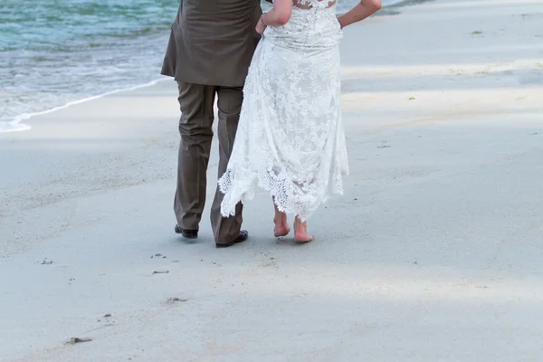 Pareja casada cogida de la mano en la playa —  Fotos de Stock