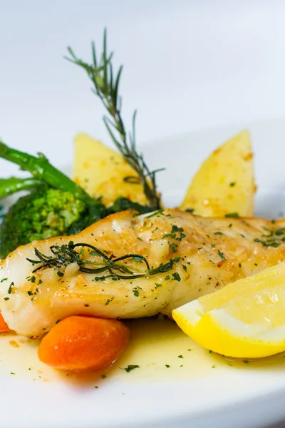 Snow fish with a butter, lemon and rosemary — Stock Photo, Image