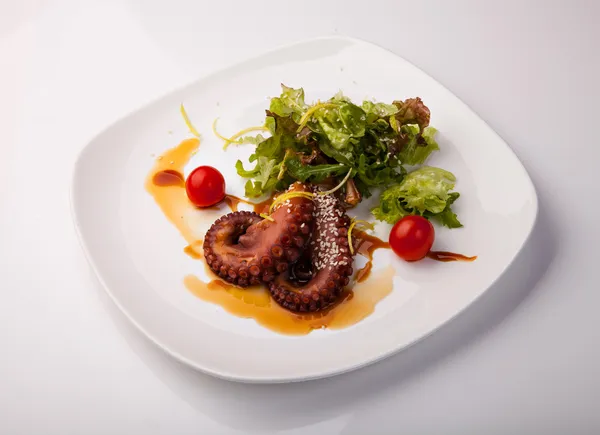 lezzetli ahtapot salata meze tabağı üzerinde yeşil salata ile