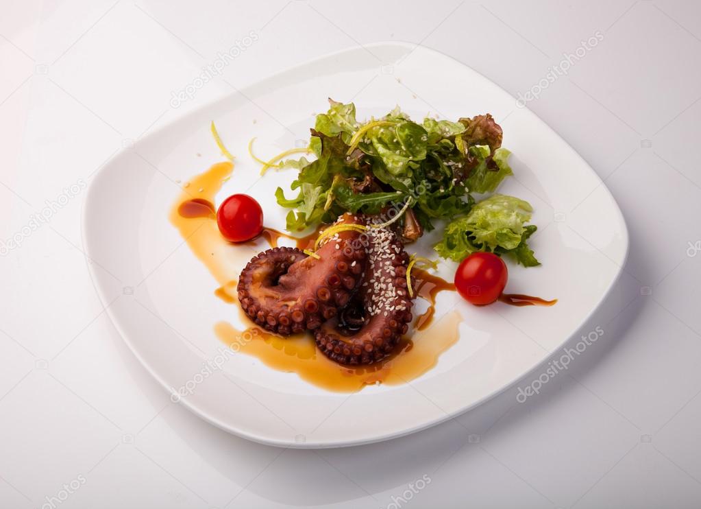 Delicious octopus salad appetizer with green salad on plate — Stock