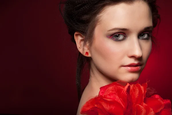 赤いバラの花を持つ女性の顔 — ストック写真