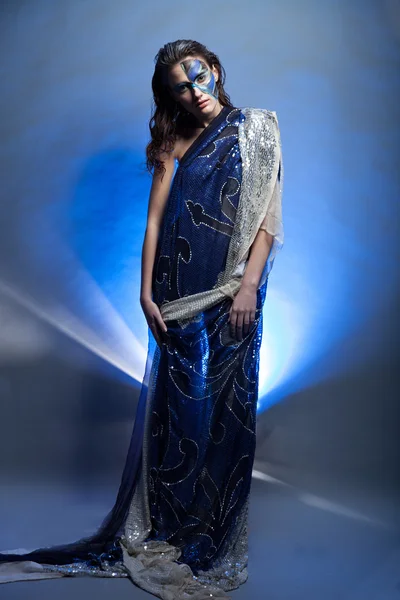 Красивая брюнетка в синем платье с цветом лица — стоковое фото