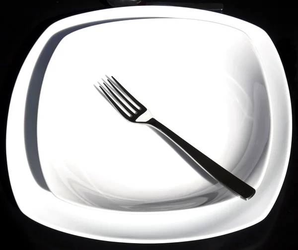 Ein weißer Teller mit silberner Gabel — Stockfoto