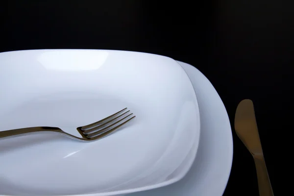 A white plate with silver fork — Stock Photo, Image