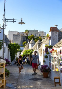 ALBEROBELLO, İtalya: 7 Ağustos 2021: Turistler, Trulli 'si ile ünlü Alberobello kasabasını ziyaret ettiler 