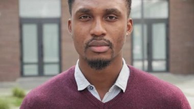 Şık Afro-Amerikan iş adamı ofis merkezinin yanında duruyor..