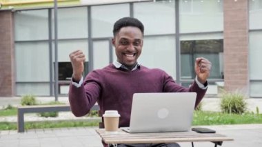 Afrikalı Amerikalı adam internetten gelen iyi habere seviniyor. Başarılı bir anlaşma.