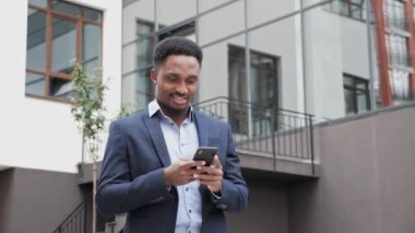 Dışarıda cep telefonu kullanan yakışıklı siyahi girişimci iş adamı. İş dünyası.