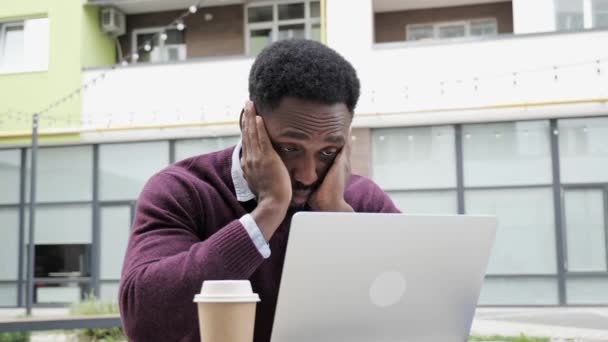 Afro American Man reaccionando a la pérdida mientras usa el ordenador portátil al aire libre. — Vídeos de Stock