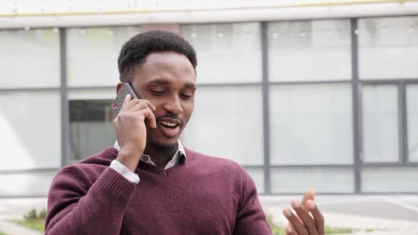 Όμορφος μαύρος επιχειρηματίας που μιλάει στο τηλέφωνο στο δρόμο. — Αρχείο Βίντεο