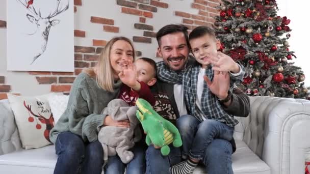 Щаслива подружня пара з двома дітьми подає фотоапарат Веселого Різдва.. — стокове відео