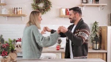 Ev mutfağında dans eden genç çift. Mutlu kış tatilleri Yeni yıl konsepti.