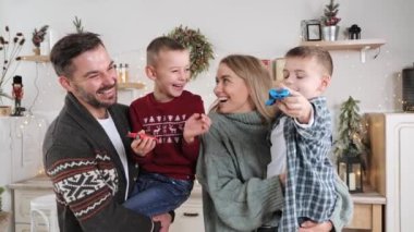 Mutlu ebeveynler çocuklarını kollarına alıp eğleniyorlar Mutlu Noeller.