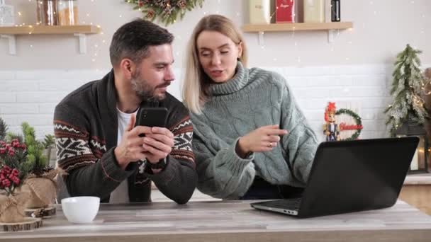 Пара, делающая покупки Xmas онлайн на смартфоне и ноутбуке Новогодние продажи. — стоковое видео