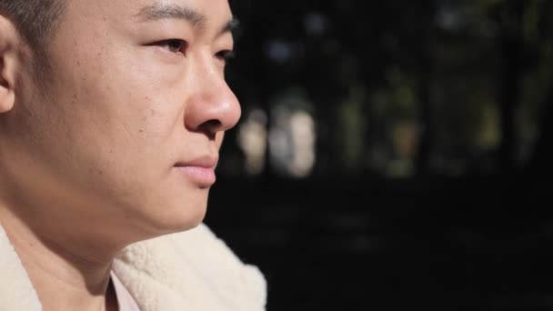 Hombre asiático mirando hacia otro lado con emoción viva. Gente emociones al aire libre concepto. — Vídeos de Stock