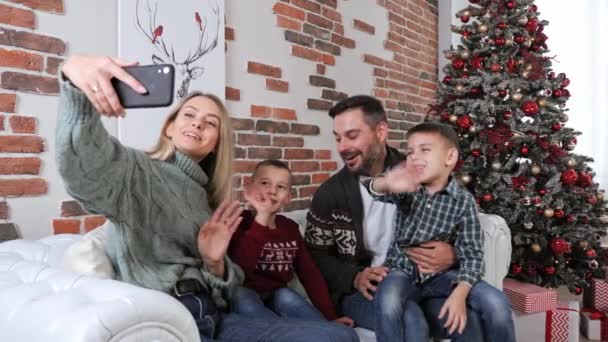 Sonriente familia con dos niños varones mamá y papá grabar en video Navidad. — Vídeo de stock
