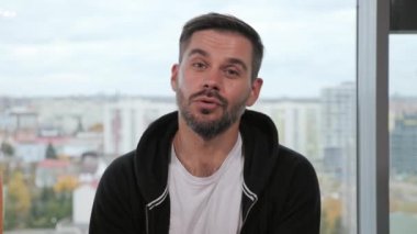 Genç yakışıklı sakallı adamın web kamerasına bakıp arkadaşlarıyla konuştuğu yakın plan. Motive olmuş erkek iş adayı uzak bir görüşme yapıyor. Başarılı iş adamı müşterilerle çevrimiçi pazarlık yapıyor.