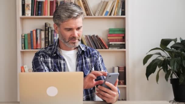 Inteligente masculino profesional celebración de teléfono inteligente moderno y mensaje de texto en casa. — Vídeos de Stock