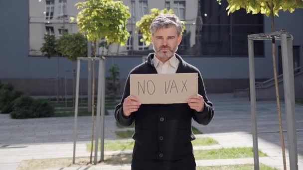 Concepto de fobia a la vacunación. Hombre adulto sosteniendo cartel No VAX en protesta. — Vídeos de Stock