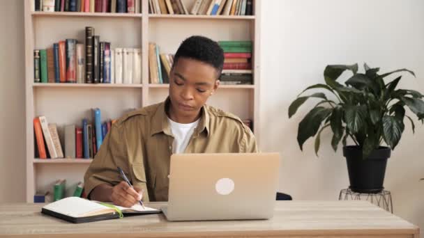 Konzentrierter afrikanischer Lehrer nutzt Laptop für Online-Konferenz am Arbeitsplatz. — Stockvideo