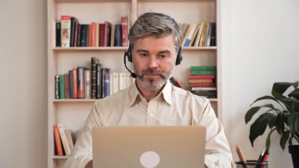 Χειριστής υποστήριξης πελατών επικοινωνεί με ακουστικά και μικρόφωνο σε εσωτερικούς χώρους. — Αρχείο Βίντεο