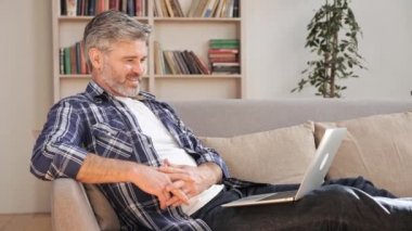 Adam işten sonra dinleniyor ve kanepede biraz dinlenirken film izliyor..