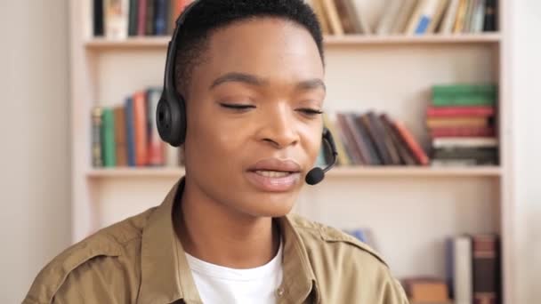 Confiado negro mujer de negocios en auriculares haciendo chat distante de trabajo desde casa. — Vídeos de Stock