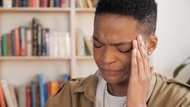 Stressad svart kvinna med smärtsamma huvudkänslor på grund av datoröverarbete. — Stockvideo