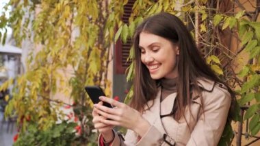 Şanslı iş kadını dışarıda cep telefonundan iyi haberler okumaktan çok mutlu..