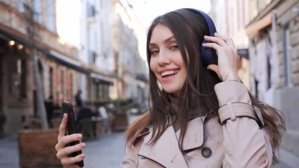 Mulher atraente com sorriso encantador ouvir música em fone de ouvido sem fio. — Vídeo de Stock