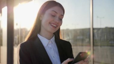 Başarılı bir iş kadını. Gün ışığında sokakta telefon kullanıyor..