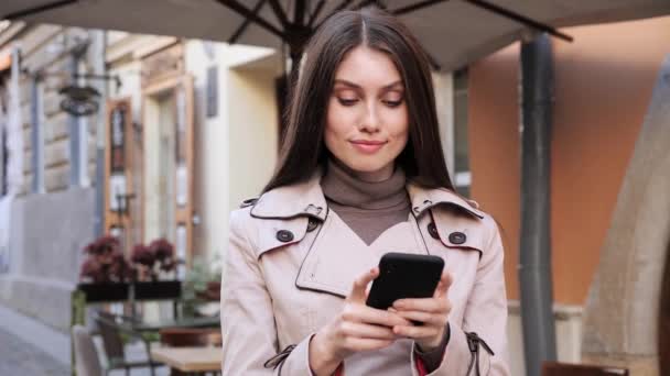Menina morena lindo navegando Smartphone moderno usando a nova App de mídia social. — Vídeo de Stock