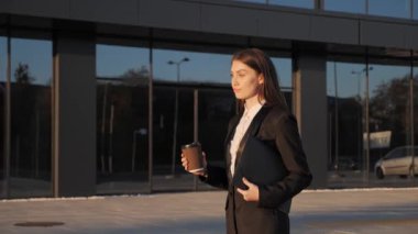  Başarılı, kendine güvenen bir kadın gün batımında yürüyor..