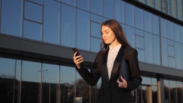 Mulher bonita usando Smartphone andando através do distrito de negócios. — Vídeo de Stock