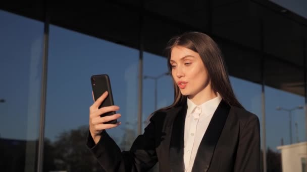 Adorable businesswoman making holding video call with colleagues outdoors. — Stock Video