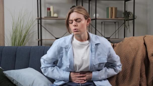 患胃痛的金发生病妇女坐在沙发上，胃炎腹泻 — 图库视频影像